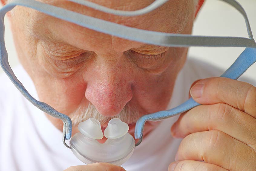 COPD patient putting on a CPAP mask