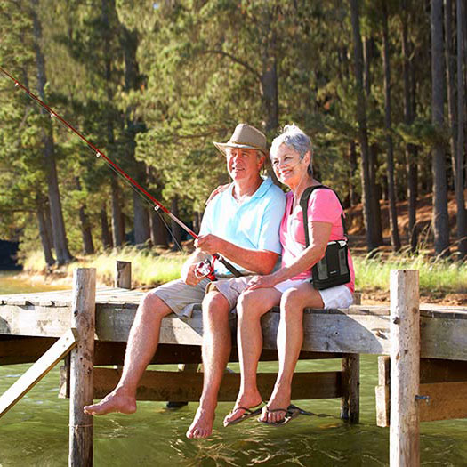 Older couple fishing at a lake with portable oxygen