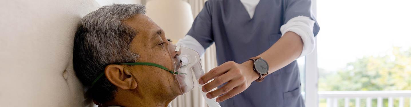 Therapist helping patient with new respiratory device at home