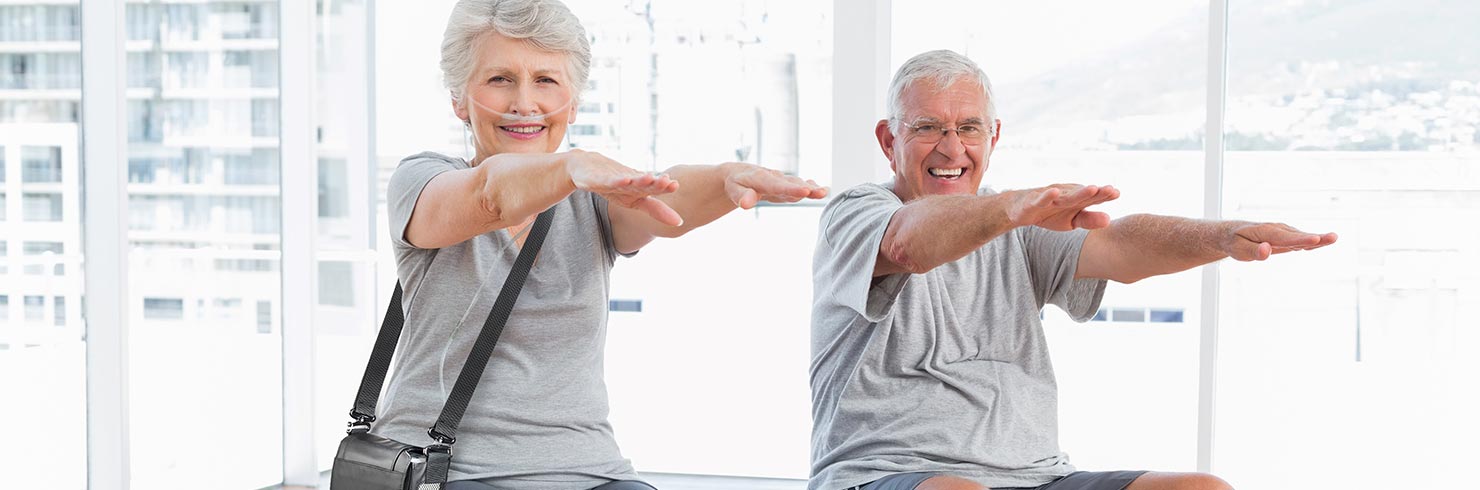 Elderly couple in exercise class with G5 portable oxygen